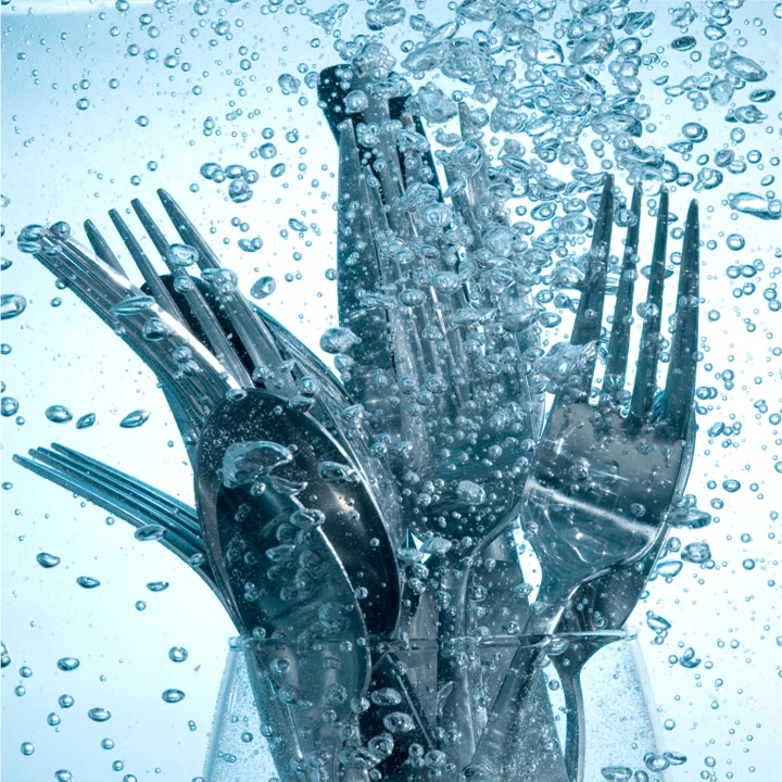 Cubiertos lavandose en un lavavajillas