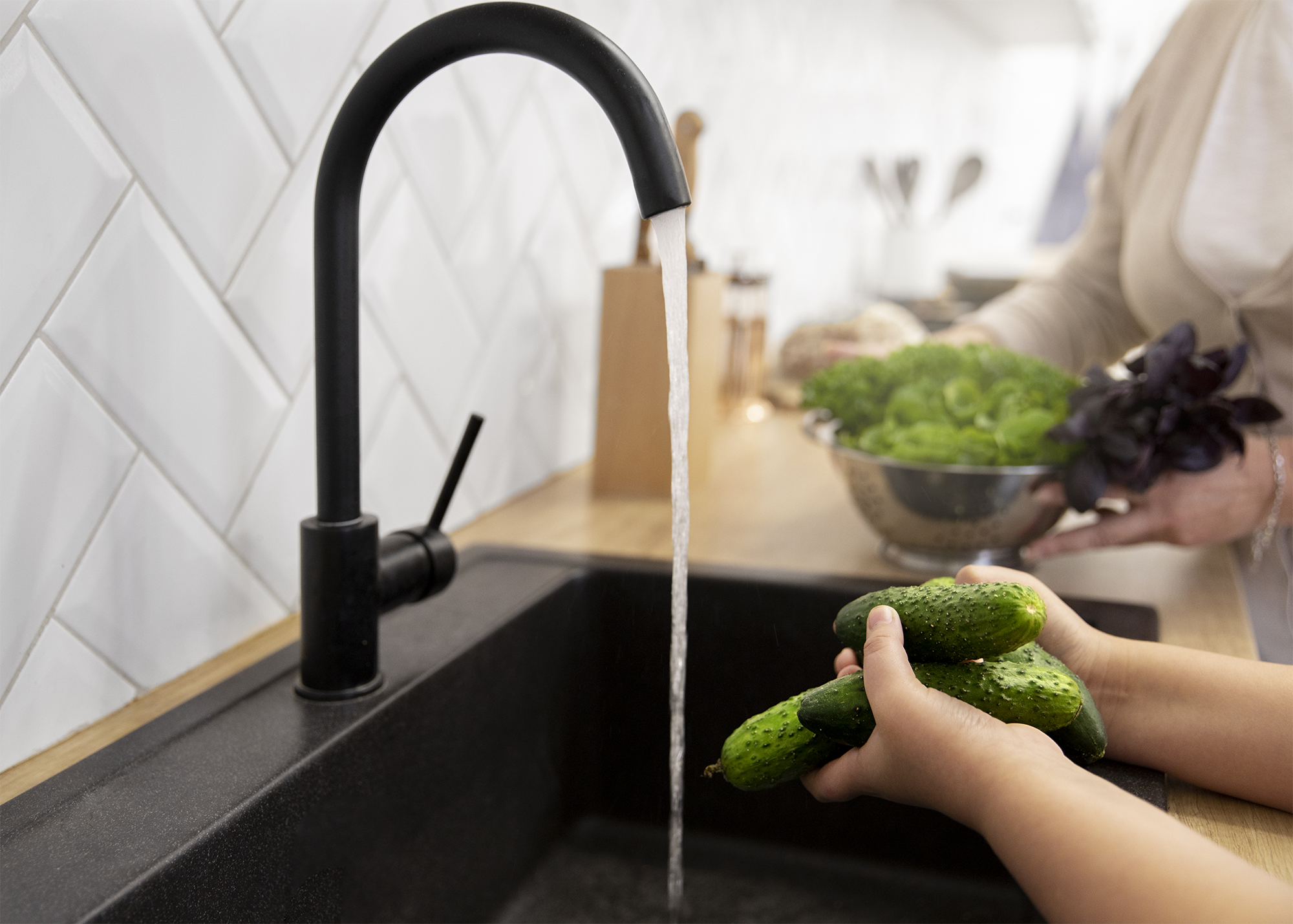 Lavando pepinillos en el grifo de la cocina