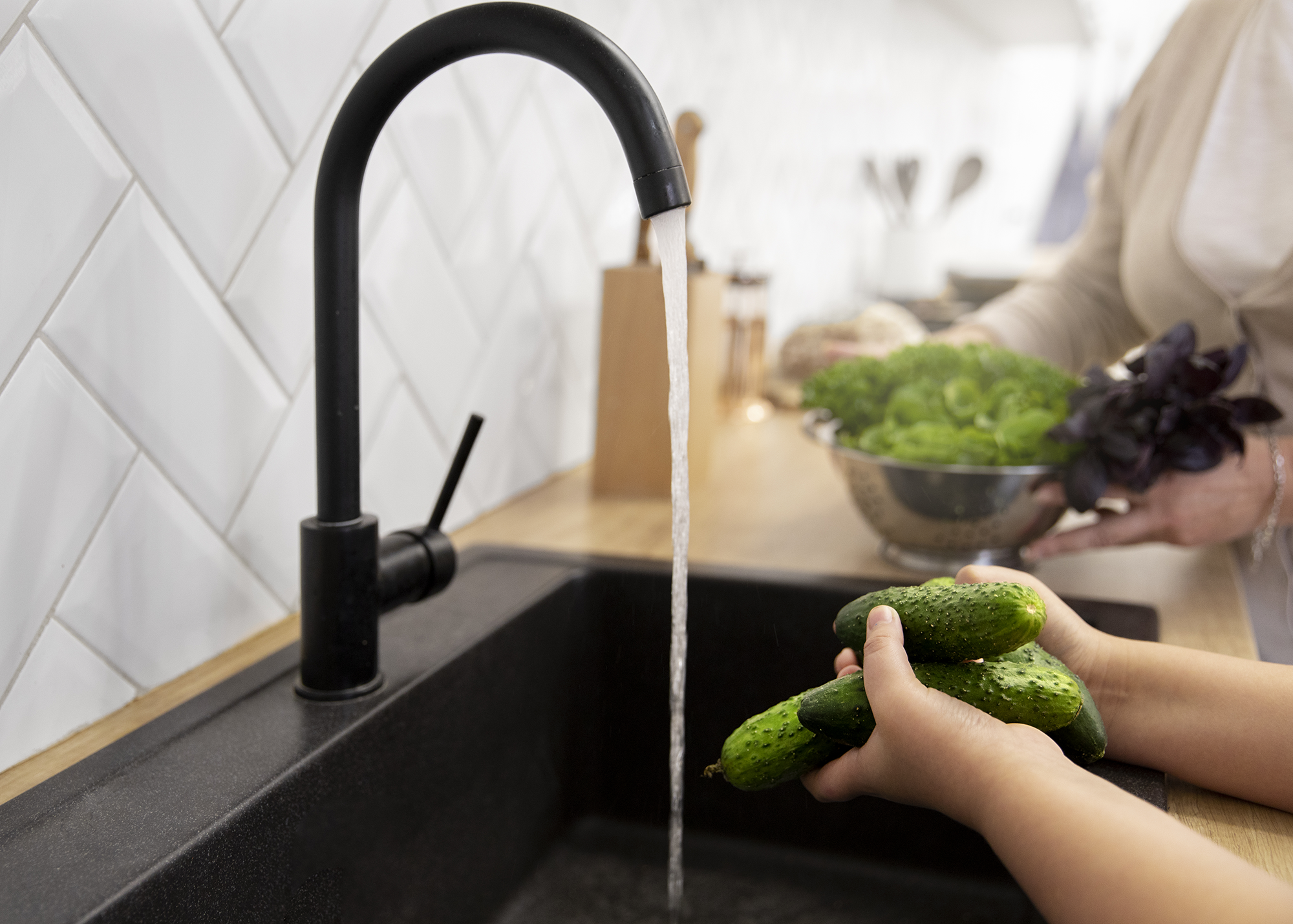 Lavando pepinillos en el grifo de la cocina