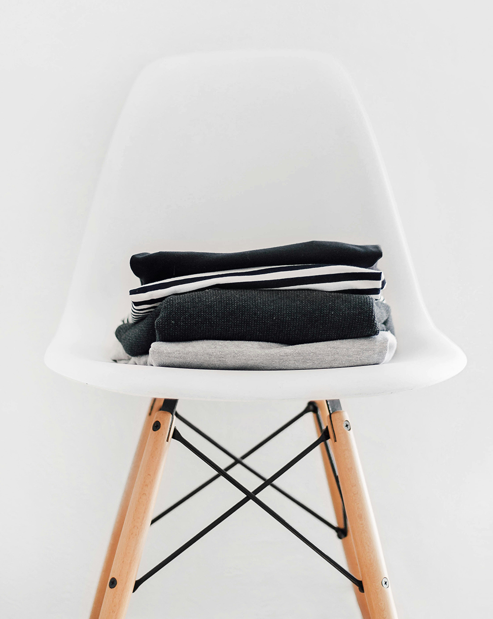 Ropa oscura doblada y colocada encima de una silla